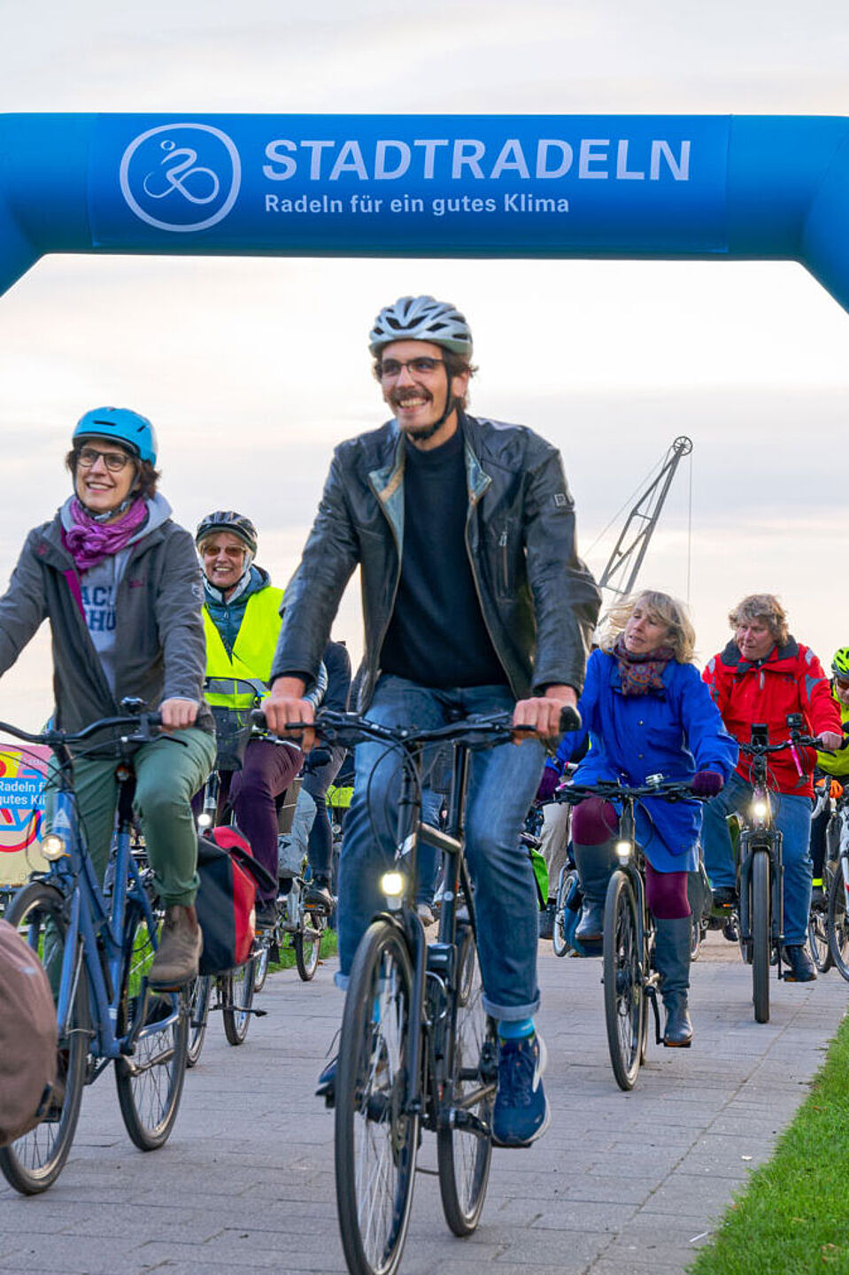 2024-09-30_Abradeln_fuers_Stadtradeln Gruppe Radfahrender fährt durch einen Torbogen